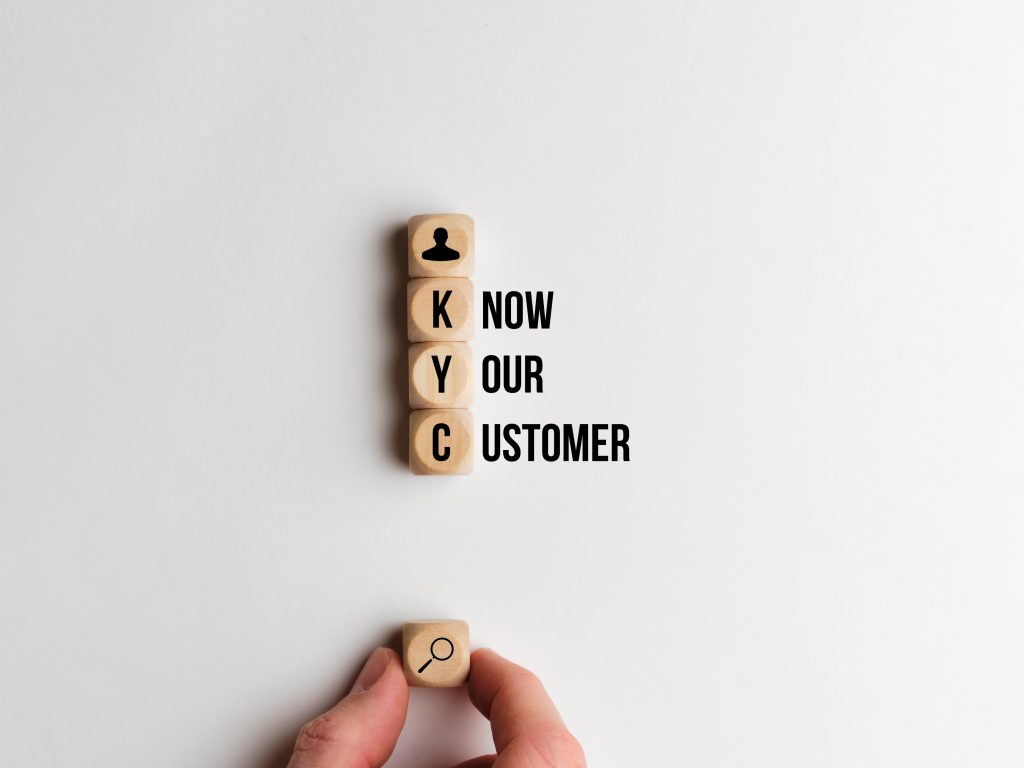 Wooden blocks stacked vertically displaying the letters 'KYC' with the words 'Know Your Customer' written beside them, highlighting the importance of understanding customer needs.